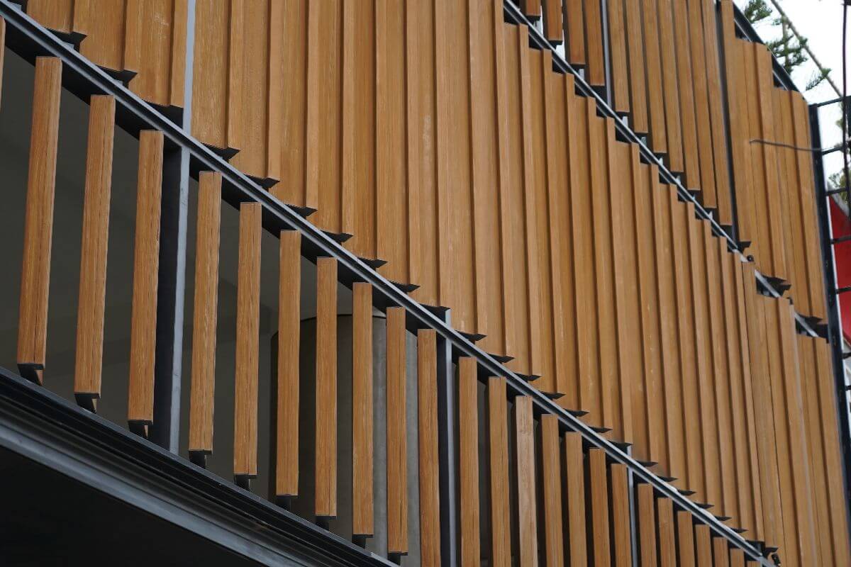 Wood-look vertical louvers used as privacy screens on a building facade