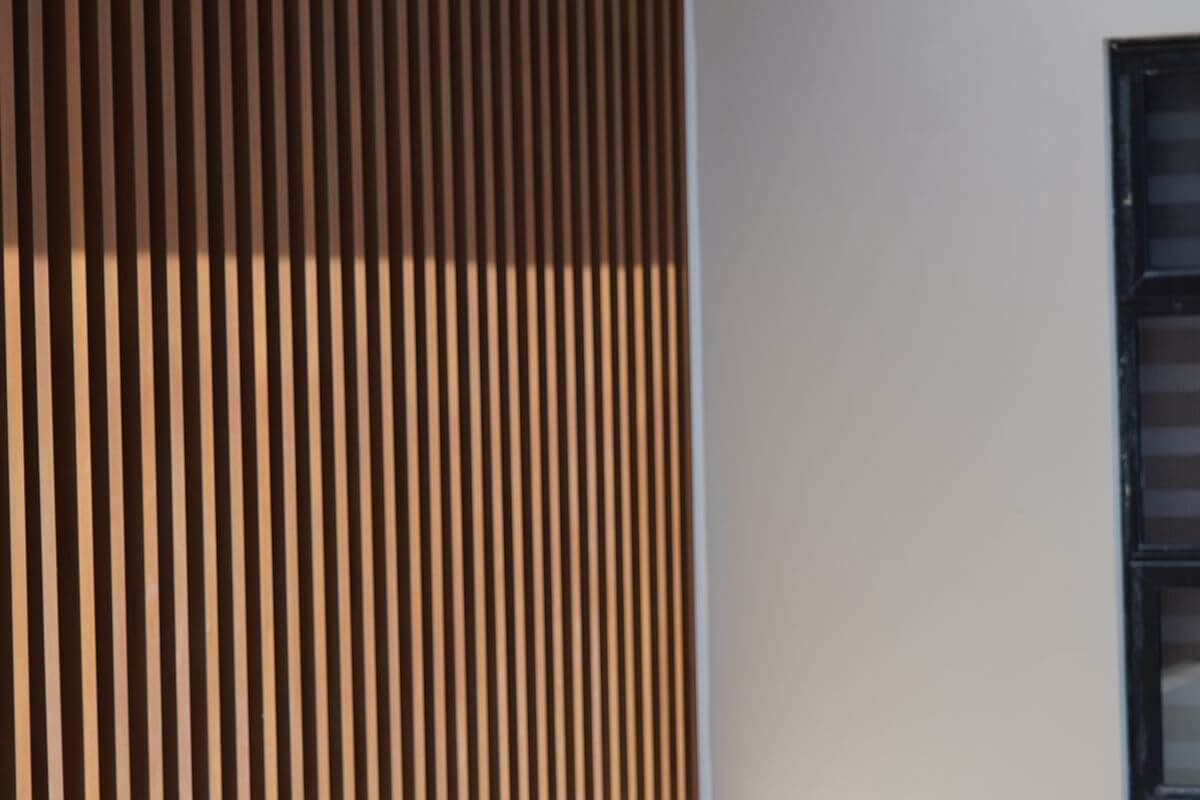 Close-up of vertical WPC wall cladding used as a warm architectural backdrop for a commercial interior