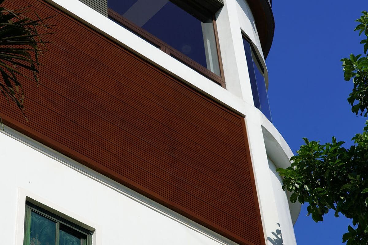 Close-up of wood-look exterior wall cladding installed on a modern building facade