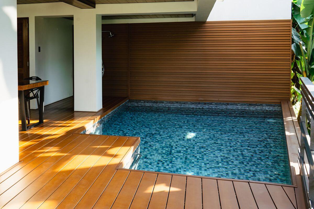 WPC wall cladding and decking installed around a residential pool area exposed to moisture